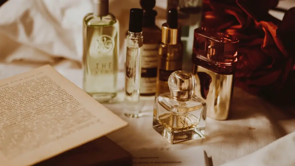 Quelques flacons de parfum posés autour d'un livre ouvert